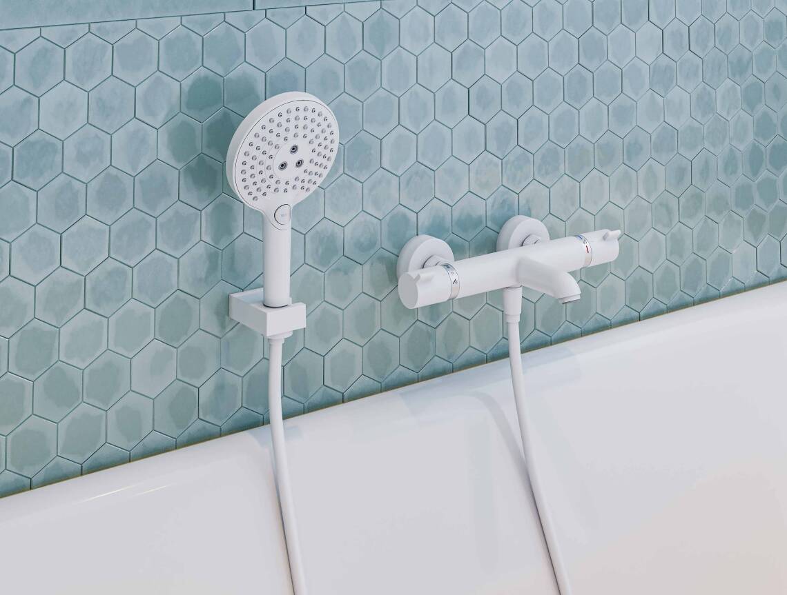 Bát sen cầm tay bên bồn tắm bề mặt màu trắng.