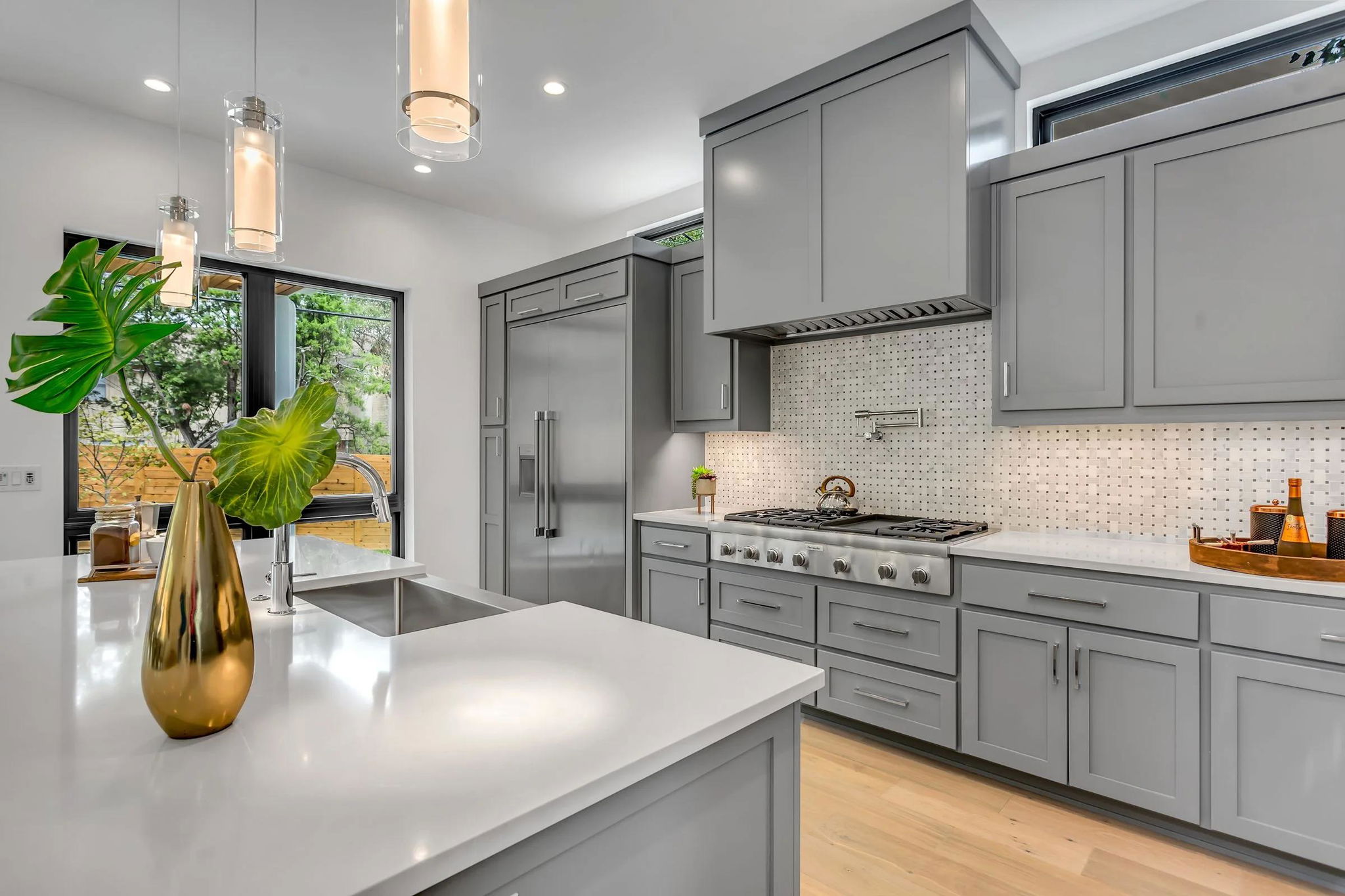 Bếp nhà phố tủ xám hiện đại với thiết bị inox và cửa sổ nhìn ra vườn — dự án nhà phố liền kề Le Phan Living